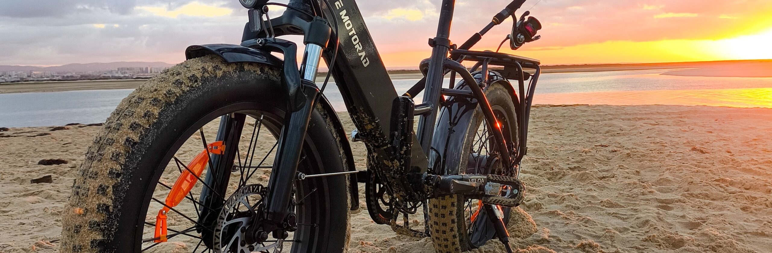 EMotorad Veloa na praia ao pôr do sol