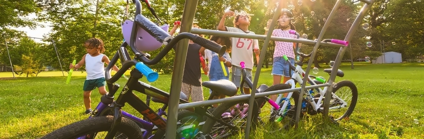 Crianças a brincar com bolas de sabão junto a bicicletas Huffy num parque