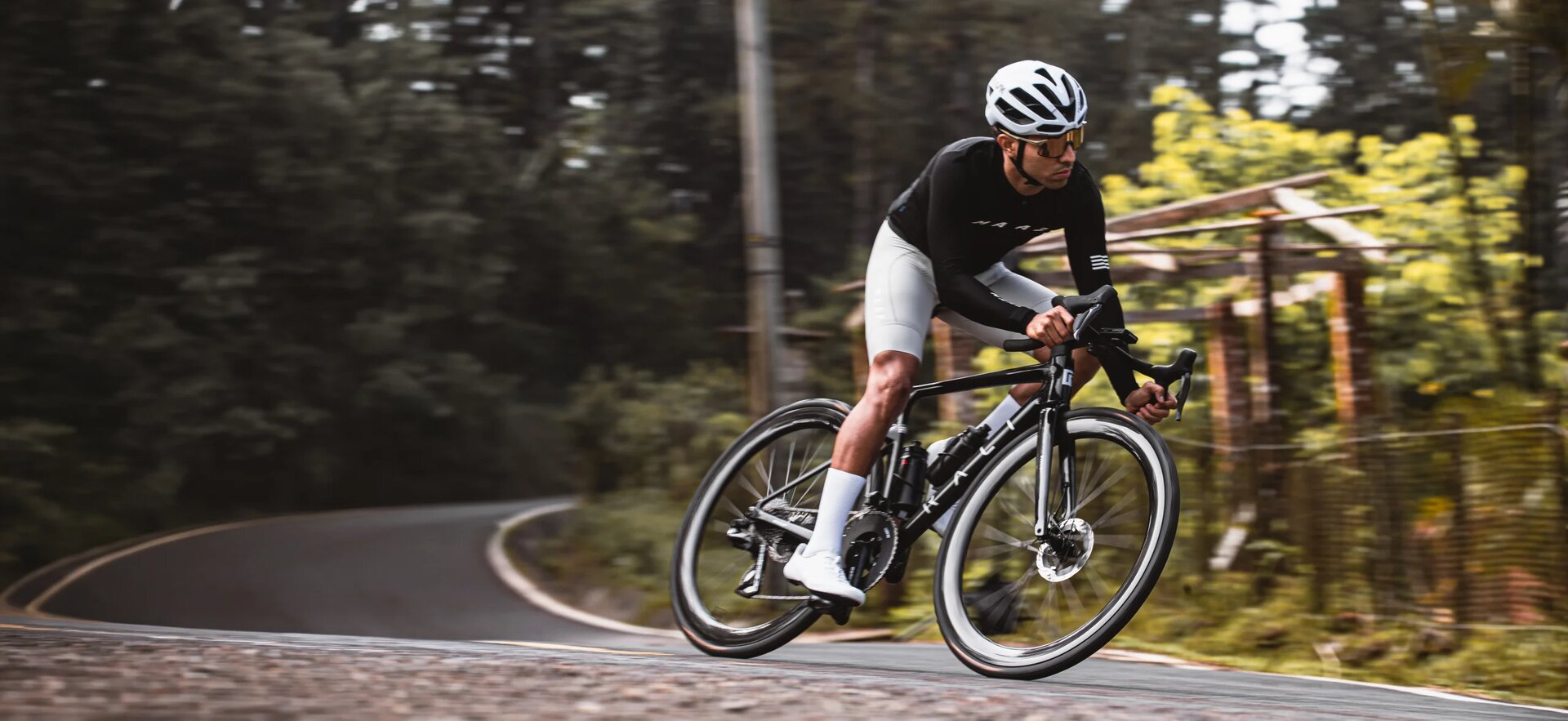 Ciclista numa Rali Evolve Carbon Raw a descrever uma curva na estrada